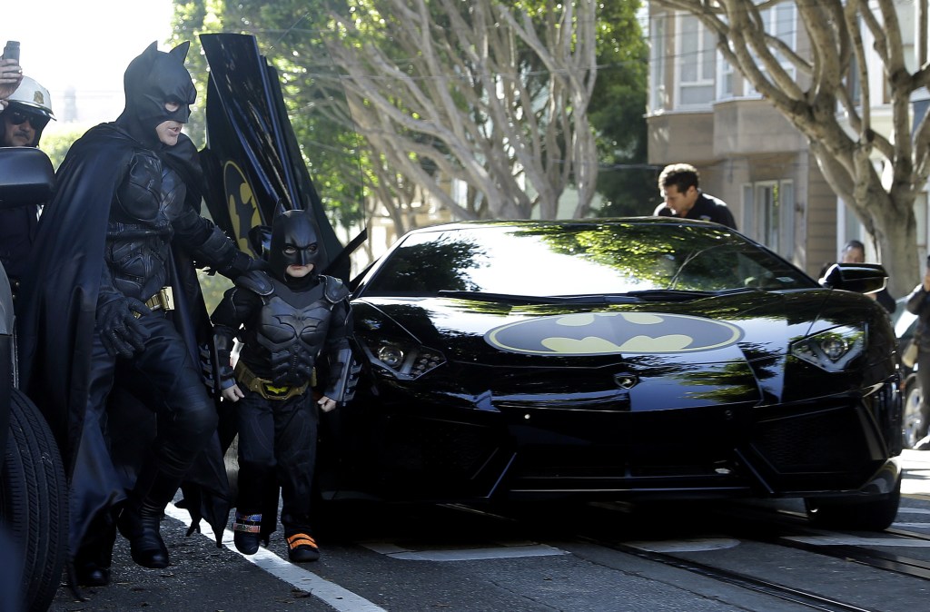 Miles Scott, dressed as Batkid, exits the Batmobile with Batman to save a damsel in distress in San Francisco, on Friday.