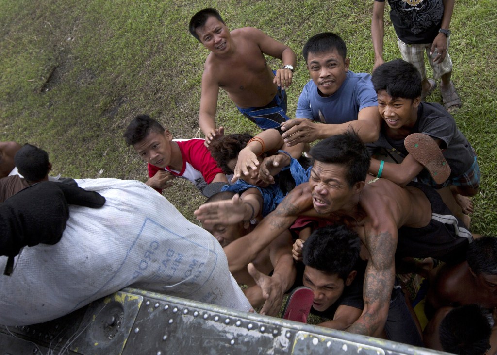 Villagers stranded by Typhoon Haiyan scramble for aid from a U.S. Navy Sea Hawk helicopter in the coastal town of Tanawan, central Philippines, on Sunday. Typhoon Haiyan, one of the most powerful storms on record, hit the country’s eastern seaboard Nov. 8, leaving a wide swath of destruction.