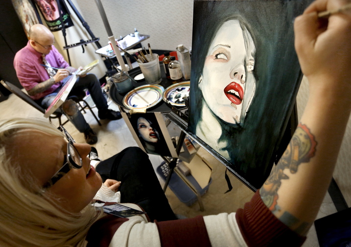 Artist Lila Rees works on an untitled piece alongside artist Chris Dingwell during Coast City Comicon.
