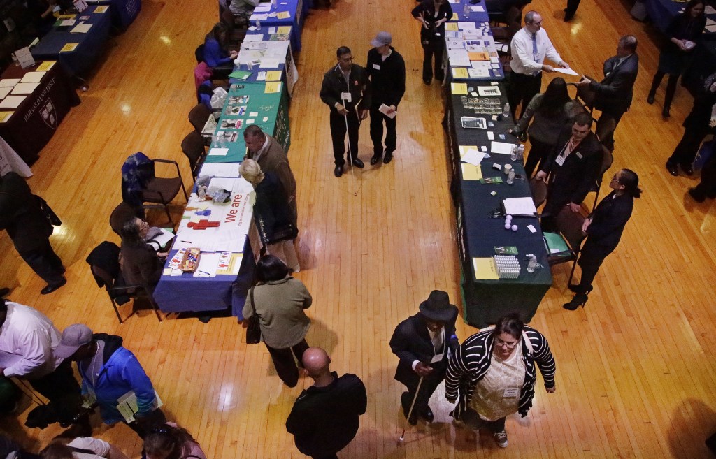 Job seekers and their volunteer guides attend a job fair for the visually impaired in the former Radcliffe College gymnasium, at Radcliffe Yard in Cambridge, Mass., last month. Helen Keller exercised here en route to becoming the first deaf/blind person to earn a bachelor of arts degree in 1904.