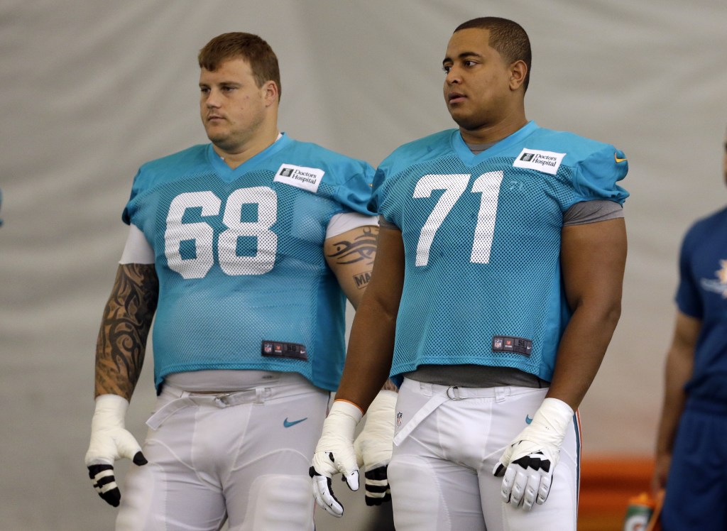 FILE - In this July 24, 2013 file photo, Miami Dolphins guard Richie Incognito (68) and tackle Jonathan Martin (71) stand on the field during an NFL football practice in Davie, Fla. Two people familiar with the situation say suspended Dolphins guard Incognito sent text messages to teammate Jonathan Martin that were racist and threatening. The people spoke to The Associated Press on condition of anonymity because the Dolphins and NFL haven't disclosed the nature of the misconduct that led to Incognito's suspension. Martin remained absent from practice Monday, Nov. 4, 2013, one week after he suddenly left the team. (AP Photo/Lynne Sladky, File)
