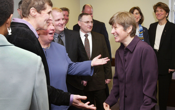 Attorney Mary Bonauto, right, smiles while surrounded by gay couples on March 4, 2003, after a news conference in Boston following oral arguments at the Supreme Judicial Court on their challenge to the state’s prohibition on gay marriage.