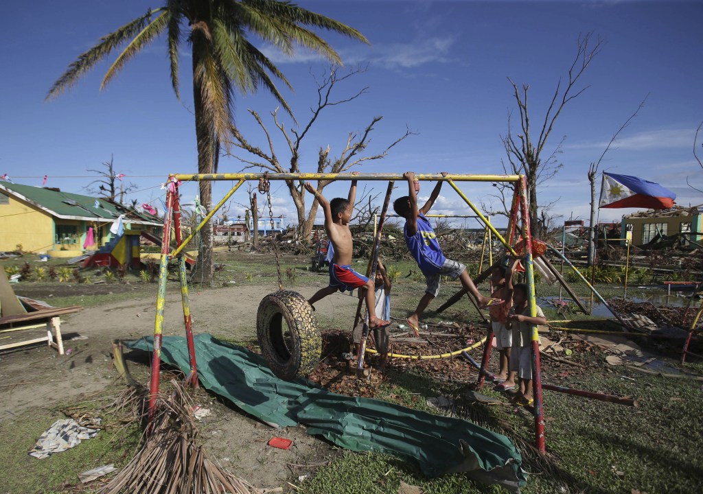 Children play on the playground of the typhoon damaged Pawing Elementary School in Palo town, Leyte province, central Philippines Tuesday, Nov. 19, 2013. Hundreds of thousands of people were displaced by Typhoon Haiyan, which tore across several islands in the eastern Philippines on Nov. 8.