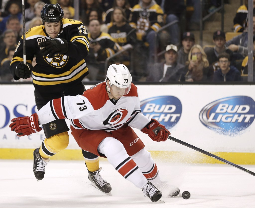 Carolina’s Brett Bellemore gets a step ahead of a leaping Milan Lucic during Saturday afternoon’s game in Boston, won by the Bruins on David Krejci’s overtime goal.