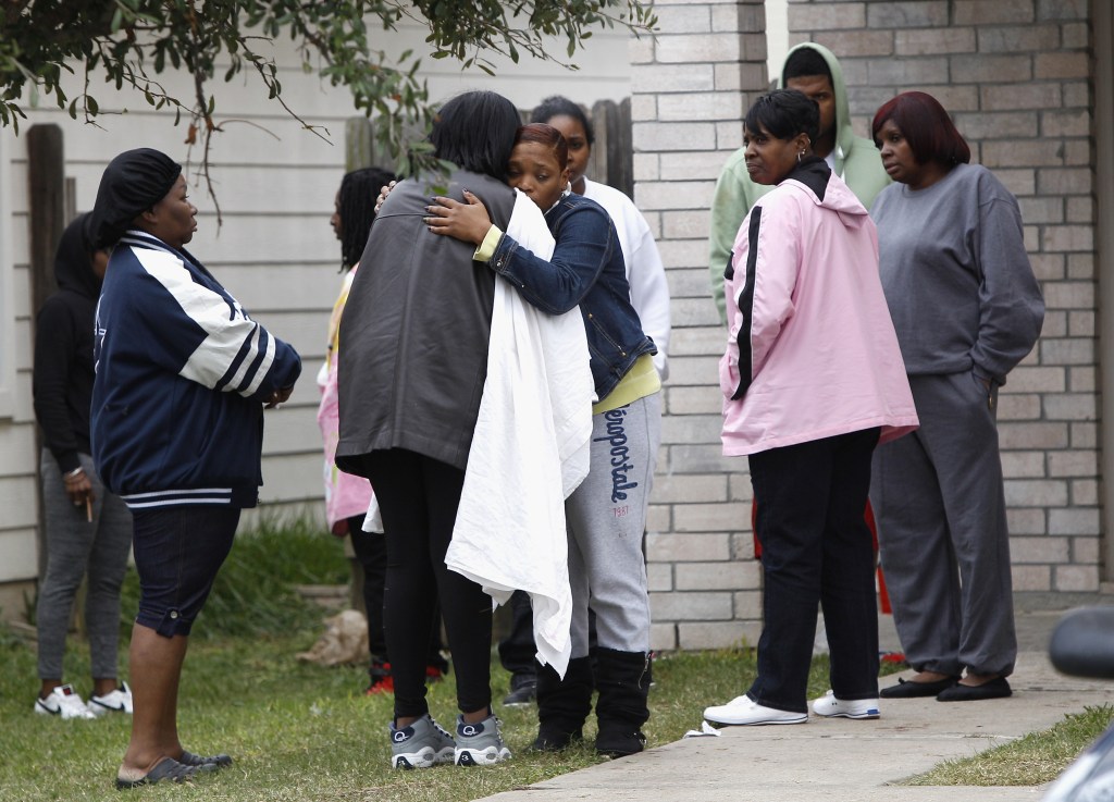 Family and friends console each other outside 7318 Enchanted Creek in Cypress, Texas, on Sunday, after two people were killed and at least 22 others were injured Saturday night when gunfire rang out at a large house party in a Houston suburb, sending partygoers fleeing in panic, authorities said. Authorities say they’re seeking two gunmen.