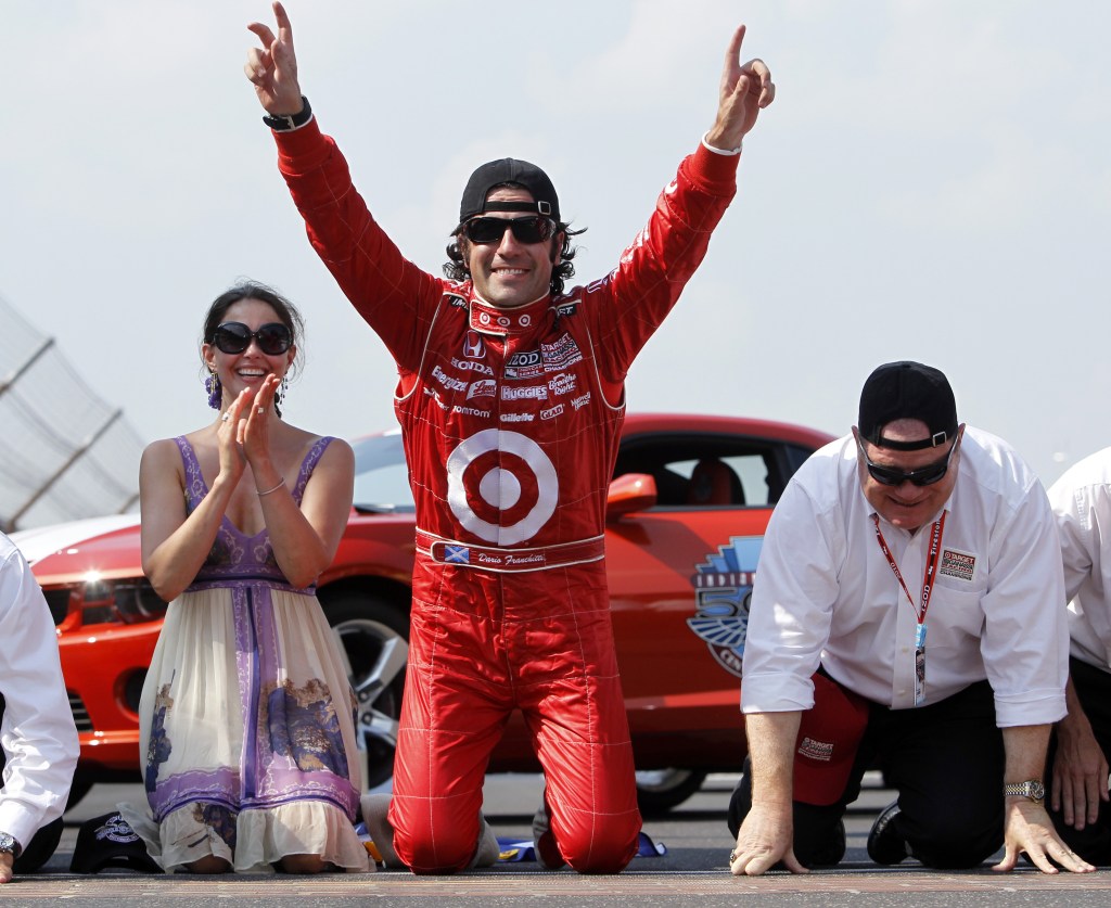 Dario Franchitti, center, of Scotland, celebrates at the start-finish line with his wife, Ashley Judd, and car owner Chip Ganassi, right, after winning the Indianapolis 500 at the Indianapolis Motor Speedway in Indianapolis in 2010.
