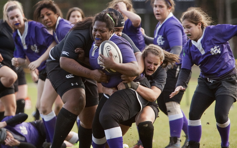 Bowdoin College women’s rugby players Pamela Zabala, left, holding onto the ball carrier, and Addison Carvajal try to tackle a Holy Cross player during a playoff game in Brunswick on Saturday. Bowdoin plays in the national quarterfinals this Saturday.