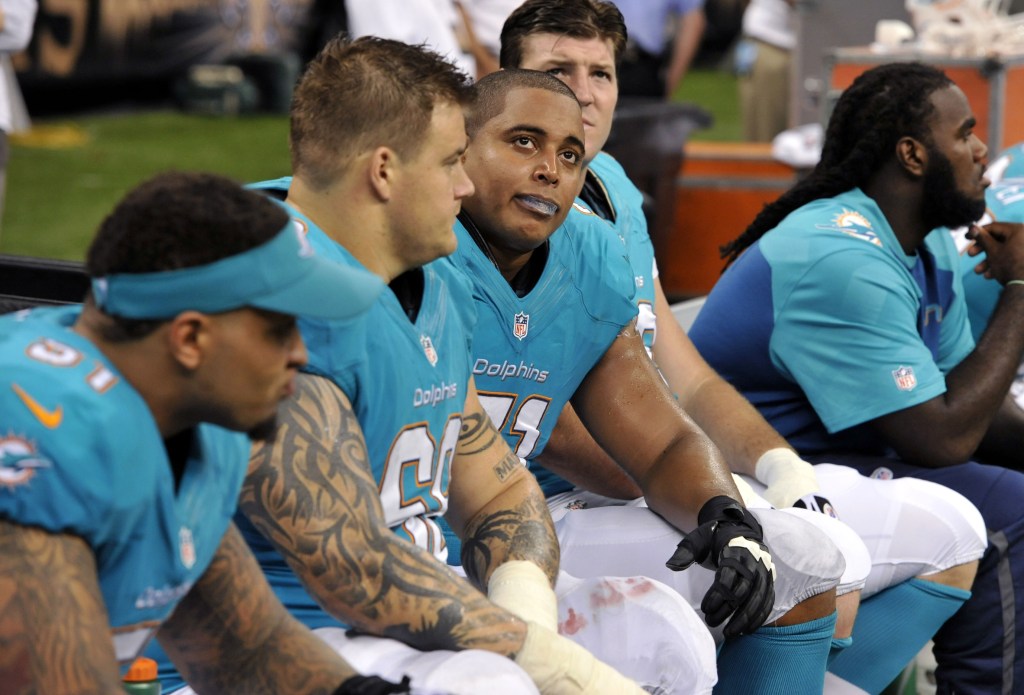 In this July 24, 2013 file photo, Miami Dolphins guard Richie Incognito (68) and tackle Jonathan Martin (71) stand on the field during an NFL football practice in Davie, Fla. Two people familiar with the situation say suspended Dolphins guard Incognito sent text messages to teammate Jonathan Martin that were racist and threatening. The people spoke to The Associated Press on condition of anonymity because the Dolphins and NFL haven’t disclosed the nature of the misconduct that led to Incognito’s suspension. Martin remained absent from practice Monday, Nov. 4, 2013, one week after he suddenly left the team.