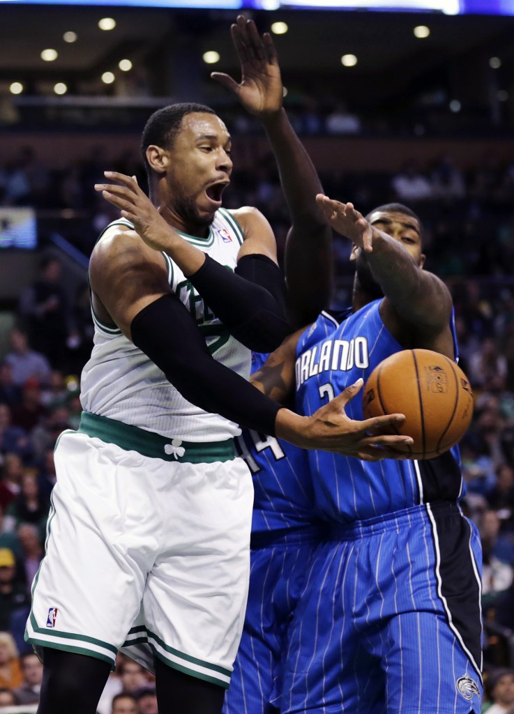 Boston’s Jared Sullinger scoops a pass under the pressure of Orlando’s Kyle O’Quinn, as the Celtics used crisp passing and shooting to beat the Magic 120-105 at Boston on Monday.