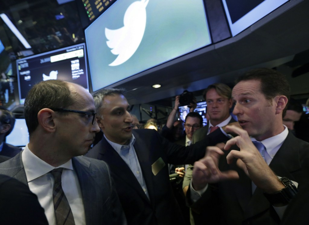 Twitter CEO Dick Costolo, left, and Mike Gupta, center, chief financial officer of Twitter, talk with specialist Glenn Carell during Twitter’s initial public offering, on the floor of the New York Stock Exchange on Thursday.