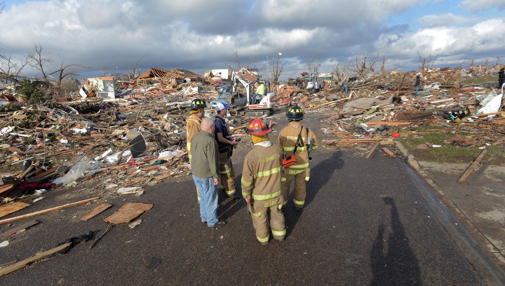 Firefighters stand in a Washington, Ill., neighborhood flattened by a tornado on Sunday. The tornado, one of dozens that rampaged across the Midwest, tore from one end of town to the other, toppling power lines, rupturing gas lines and ripping off roofs.