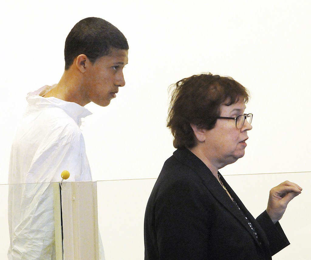 In this Oct. 23, 2013 file photo, Philip Chism, 14, stands during his arraignment for the death of Danvers High School teacher Colleen Ritzer, as his attorney Denise Regan speaks on his behalf in Salem District Court in Salem, Mass. In an indictment returned Thursday, Nov. 21, 2013, Chism was charged with sexually assaulting and killing Ritzer, and stealing her credit cards and iPhone.