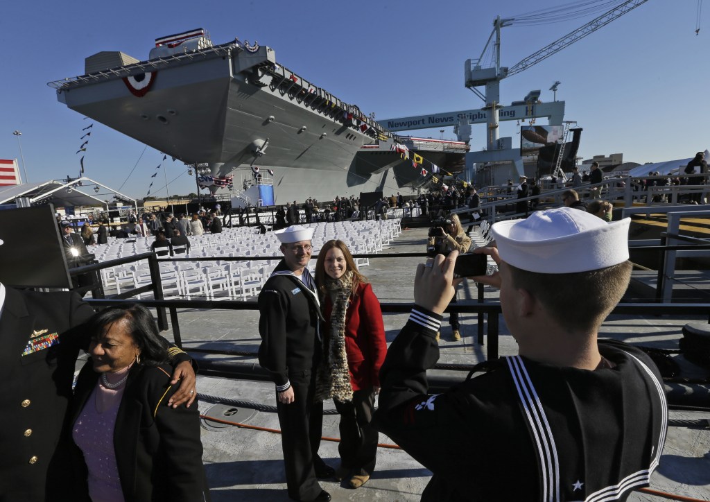 U.S. Navy Bosons mate, Ben Hansen and his wife Jessica, of Edmore Mich., are photographed in front of the Navy’s newest nuclear powered aircraft carrier USS Gerald R. Ford for the christening of the ship at the Newport News Shipbuilding in Newport News, Va., Saturday, Nov. 9, 2013. Former President Ford’s daughter Susan Ford Bales will christen the ship.)