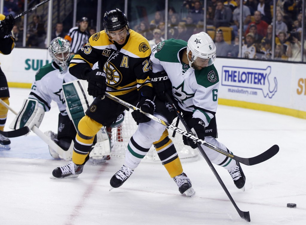 Boston Bruins center Chris Kelly tries to gain control of the puck as Dallas Stars defenseman Trevor Daley defends while Stars goalie Kari Lehtonen watches at left during the second period Tuesday night in Boston.