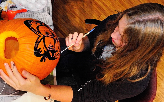 Kyara Dawbin paints a pumpkin during the after-school art program hosted by students from the University of Maine at Augusta on Wednesday at Johnson Hall in Gardiner. Students in the program say they enjoy the creative freedom and art supplies that are offered.