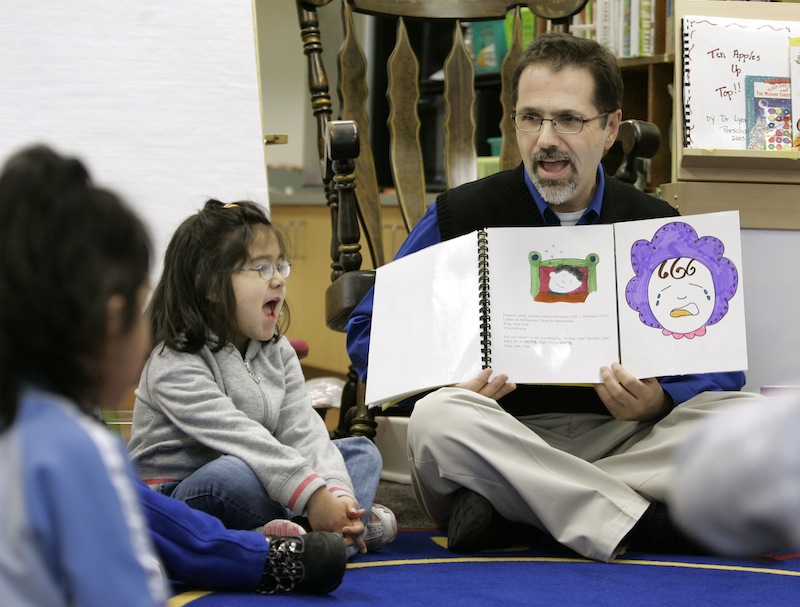 In this March 2007 file photo, Dr. Christopher Lyons, a teacher at Carlin Springs Elementary School, holds a book as he recites to pre-kindergarten students in Arlington, Va. Maine lawmakers were urged Monday to support a bill that would make Maine one of a handful of states to offer pre-kindergarten in every school district.