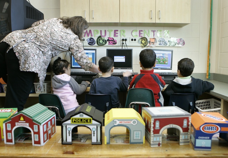 In this March 2007 file photo, teacher Ellen Vicens, left, helps pre-kindergarten students with computers at Carlin Springs Elementary School in Arlington, Va. Maine lawmakers were urged Monday to support a bill that would make Maine one of a handful of states to offer pre-kindergarten in every school district.