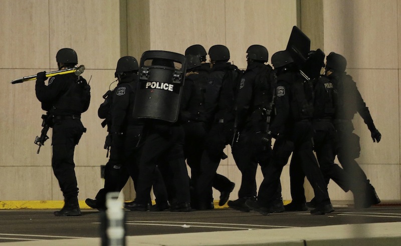 Officials wearing tactical gear walk outside of Garden State Plaza Mall following reports of a shooter, Monday, Nov. 4, 2013, in Paramus, N.J. Hundreds of law enforcement officers converged on the mall Monday night after witnesses said multiple shots were fired there.