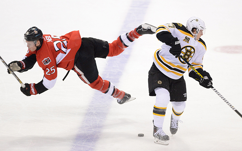 Ottawa Senators' Chris Neil, left, falls after a collision with Boston Bruins' Torey Krug during the first period of an NHL hockey game in Ottawa, Ontario on Friday, Nov. 15, 2013. (AP Photo/The Canadian Press, Sean Kilpatrick) hockey;NHL;athlete;athletes;athletic;athletics;Canada;Canadian;c