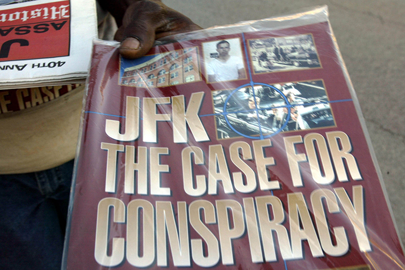 In this Saturday, Nov. 8, 2003 file photo, a vendor holds up a magazine-style publication titled "JFK The Case For Conspiracy" in downtown Dallas.