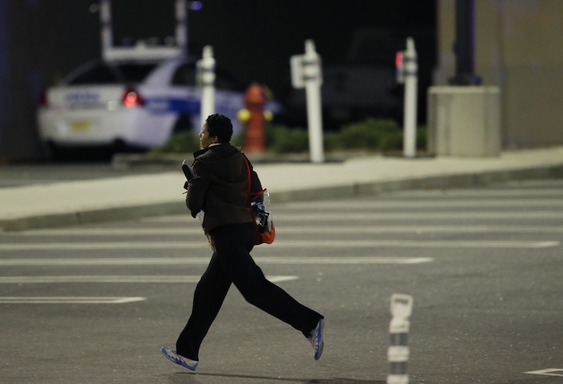 A woman runs in the parking lot of the Garden State Plaza Mall following reports of a shooter Mondayin Paramus, N.J. Hundreds of law enforcement officers converged on the mall Monday night after witnesses said multiple shots were fired there.