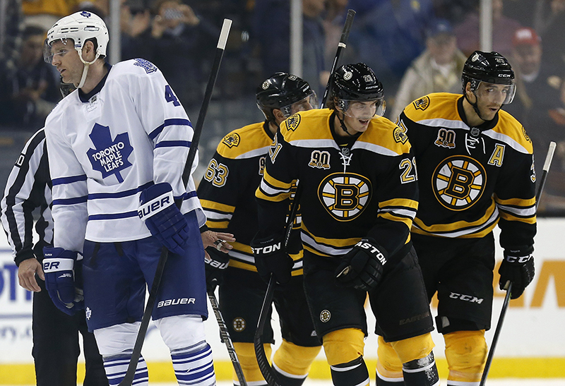 Boston Bruins' Brad Marchand (63) and Loui Eriksson (21), of Sweden, celebrate the open-net goal by teammate Patrice Bergeron, right, as Toronto Maple Leafs' Cody Franson (4) skates towards the bench in the third period of an NHL hockey game in Boston, Saturday, Nov. 9, 2013. The Bruins won 3-1. (AP Photo/Michael Dwyer)