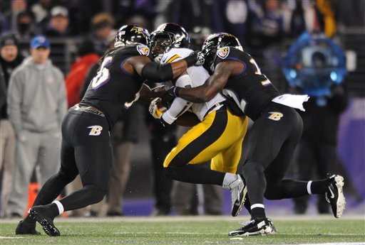 Baltimore Ravens inside linebacker Josh Bynes, left, and strong safety James Ihedigbo tackle Pittsburgh Steelers running back Le'Veon Bell in the first half Thursday in Baltimore.
