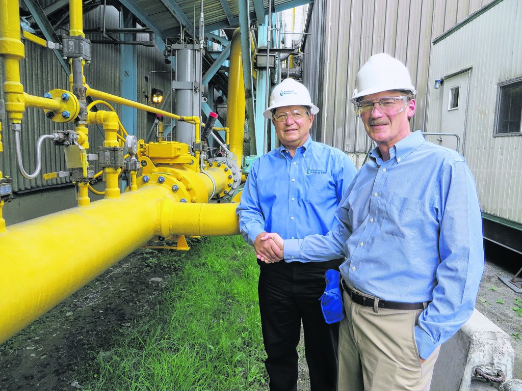 Left to right: Mike Minkos, president of Summit Natural Gas, shakes hands with Mark Gardner, president and CEO of Sappi North America.