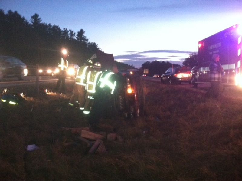 Maine State Troopers attend to an overturned car Wednesday night after an alleged hit-and-run crash on southbound I-295 in Cumberland.