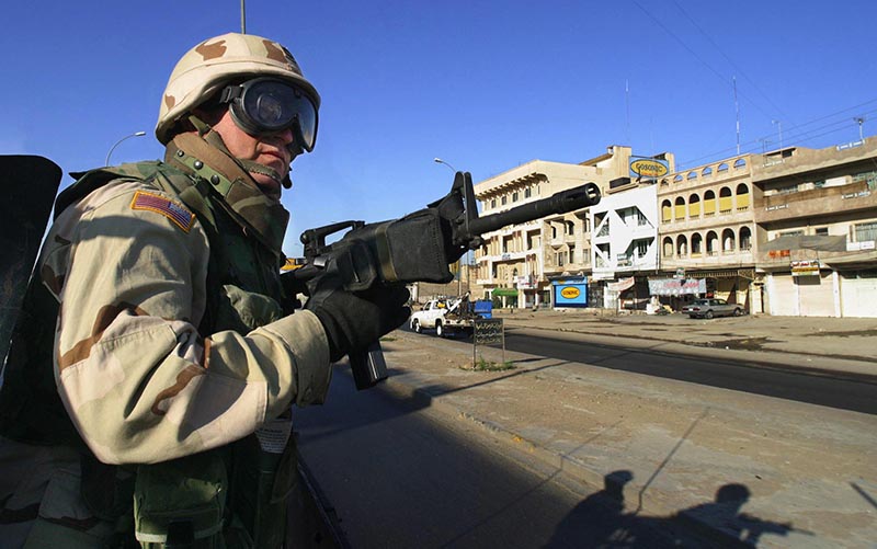 Staff photo by Gregory Rec -- Tuesday, April 13, 2004 -- With his M16 rifle locked and loaded, Sgt. 1st Class Normand Roy of Lewiston scans surrounding buildings and the roadside while riding through the city of Mosul on Tuesday. When soldiers leave their base camp on a convoy, they're on the lookout for insurgents with weapons and roadside bombs, known as IEDs (Improvised Explosive Devices). Roy is with C Company of the 133rd Engineer Battalion of the Maine Army National Guard.