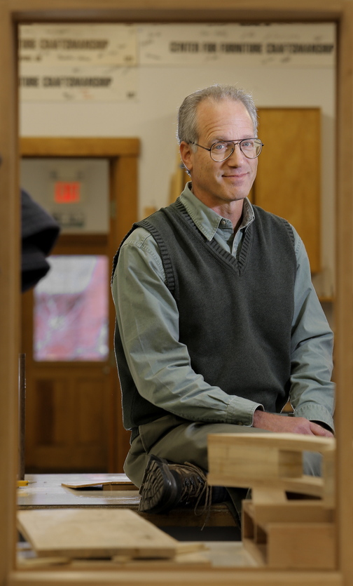 Peter Korn, director of the Center for Furniture Craftsmanship, poses for a portrait in one of the school’s classrooms. He came to Rockport in 1993, where he founded the center that has taught thousands of aspiring craftsmen the art of creating in wood. Korn’s new book, below left, is “Why We Make Things and Why It Matters: The Education of a Craftsman.” Below, Korn’s dancing swan desk.