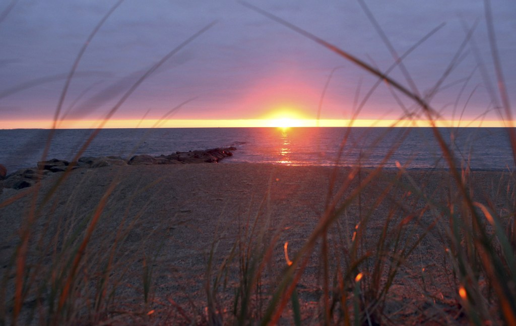 The sun rises over Nantucket Sound as seen from Popponesset Beach in Mashpee, Mass., where the Cape Wind offshore wind turbine power generation project won approval for construction. The project faces a deadline for construction to begin by Dec. 31.