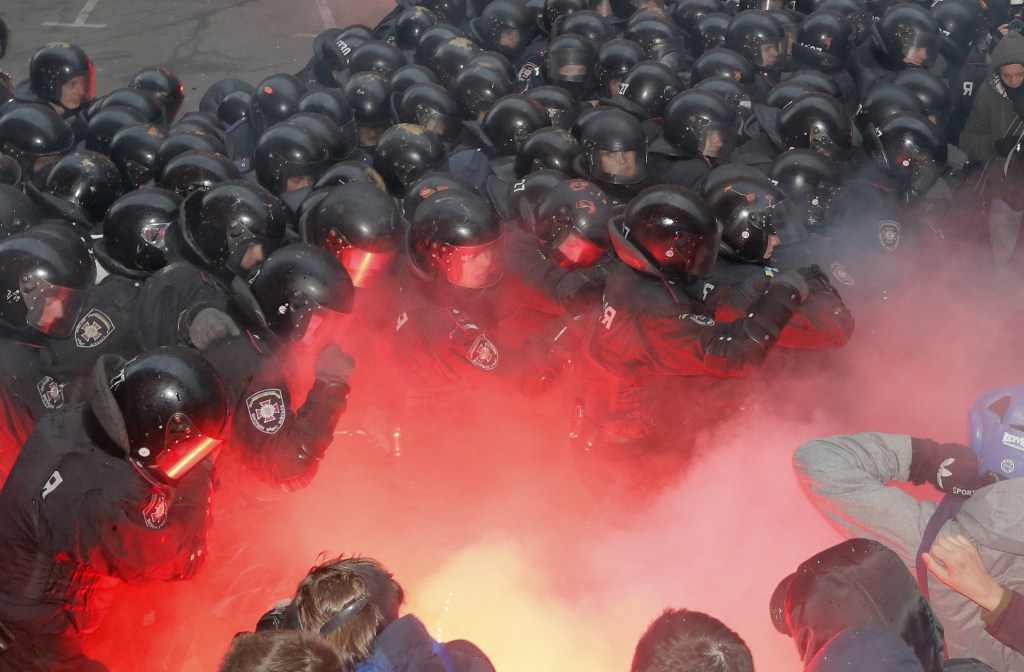 Protesters and police clash outside the presidential office in Kiev, Ukraine, on Sunday. Police drove them back with truncheons, tear gas and flash grenades.