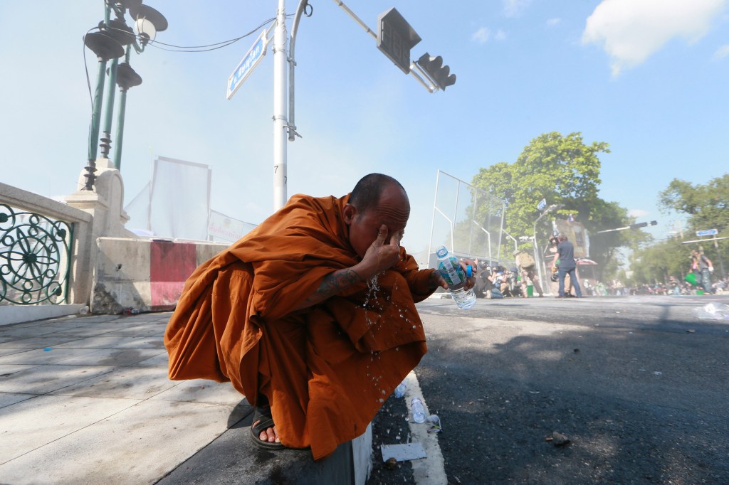 A Thai Buddhist monk washes his eyes after riot police fired tear gas at anti-government protesters in Bangkok on Sunday, the seventh day of demonstrations.