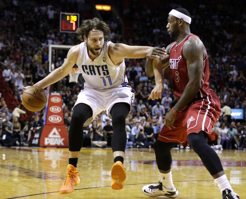 Charlotte’s Josh McRoberts drives to the basket as Miami’s LeBron James defends during second-half action in Sunday’s game at Miami, a 99-98 win for the Heat.