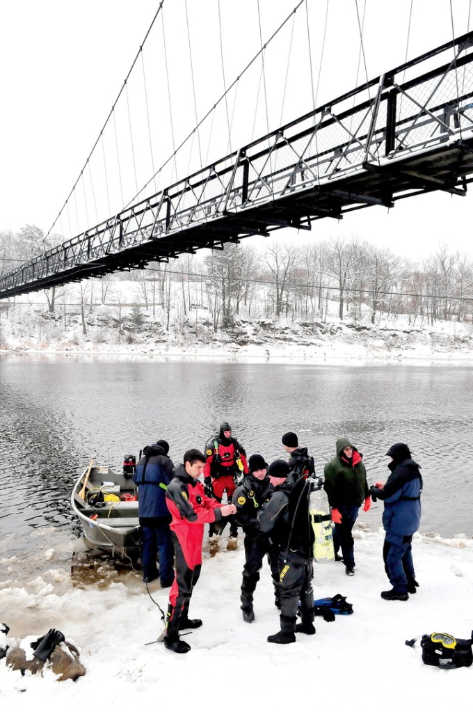 Divers with the Maine State Police and Maine Department of Marine Resources prepare to enter the Kennebec River under the Two-Cent Bridge in Waterville on Monday.