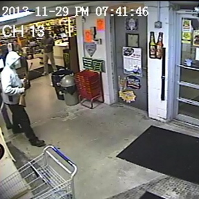 Police are seeking information on a man, seen on Friday in this security camera image, who carried a rifle into RSVP Discount Beverage on Forest Avenue in Portland.