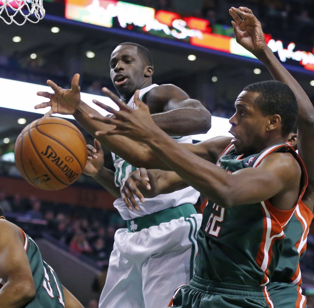 Celtics power forward Brandon Bass, middle, fights for a rebound with Milwaukee Bucks power forward Khris Middleton (22) as forward John Henson (31) ducks down, at left, in the first half in Boston on Tuesday.