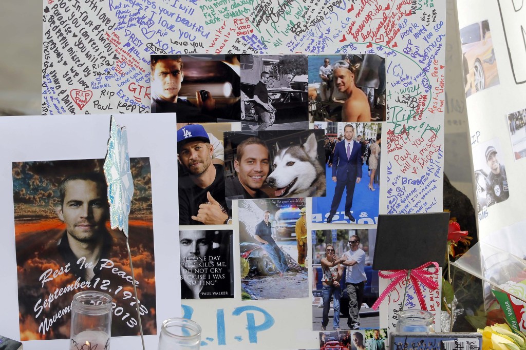 Photos and messages are seen at a roadside memorial at the site of the auto crash that took the life of actor Paul Walker and friend Roger Rodas, in Valencia, Calif.