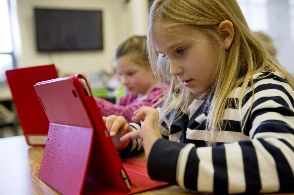 Ella Russell, 7, works on an iPad in her second-grade class at Jamestown Elementary School in Arlington, Va. Many schools need faster and more reliable Internet access.