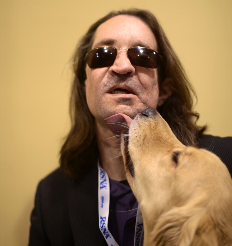 The nation’s first full-face transplant patient Dallas Wiens receives a kiss from his guide dog “Charlie” after a news conference at McCormick Place in Chicago on Wednesday.