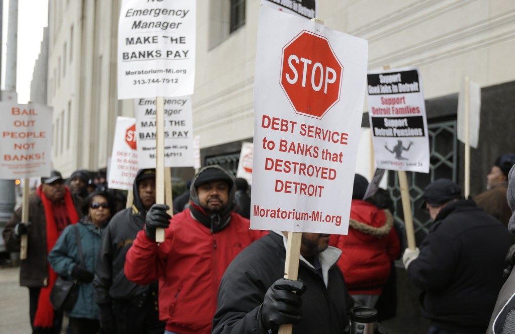Detroit city workers and supporters protest outside the federal courthouse in Detroit while awaiting the bankruptcy decision, Tuesday, Dec. 3, 2013. A judge is expected to announce Tuesday if the city is to become the biggest city in U.S. history to enter bankruptcy.