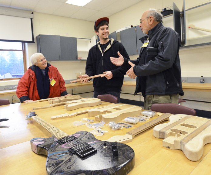 Noble High School senior Mike Lavigne shows Sandy and Dave Perloff some guitars in different stages of completion. The Perloffs provided grants to fund the class at the North Berwick school and hundreds of other Maine projects, and make it a point to revisit schools twice a year to check on the programs’ progress.