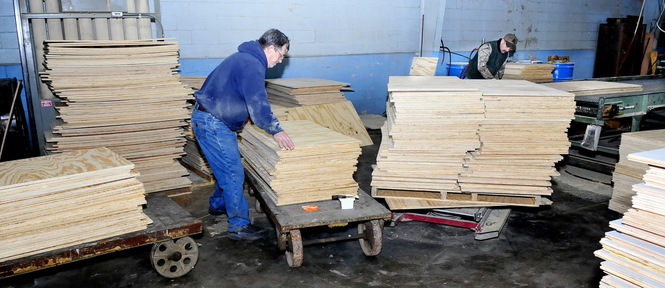 Cousineau Wood Products employees Darrell Clark, left, and Jerry Chestnut work on flooring stock at the North Anson company on Thursday.