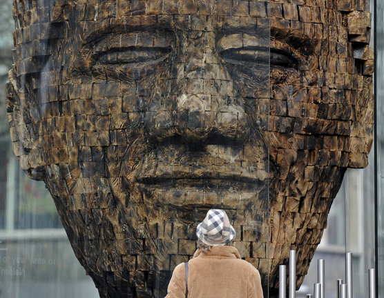 A woman views a new giant wooden sculpture of former South African President Nelson Mandela in the city center of Essen, Germany, in this Feb. 23, 2011 file photo. The artwork “Mandela, 2700 pieces of Life’s history” by artist Jems Robert Koko Bi from the Ivory Coast is made of burned spruce wood and symbolizes the fight for freedom. On Thursday, Dec. 5, 2013, Mandela died at the age of 95.