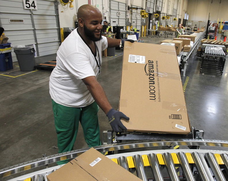 An employee places a package on the belt at an Amazon.com fulfillment center in Goodyear, Ariz., in 2010. A reader says taxes on online sales would not be new since there is already a use tax.