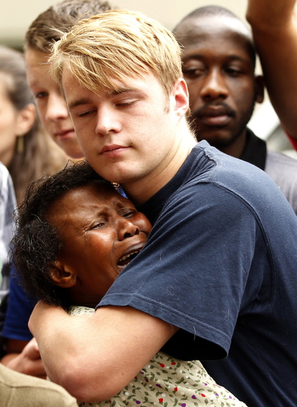 People comfort each other outside the residence of former South African President Nelson Mandela in Johannesburg on Friday.