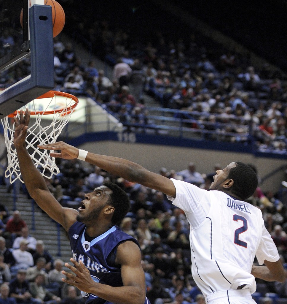 Maine’s Xavier Pollard, left, is fouled by Connecticut’s DeAndre Daniels as he goes to the basket during the first half of Connecticut’s 95-68 win at Hartford, Conn., on Friday.