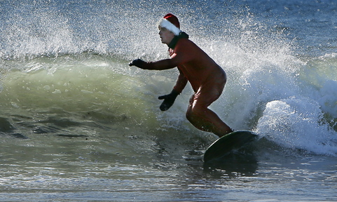 Dressed in a Santa Claus suit, Ryan McDermott of Freeport surfs at Gooch’s Beach in Kennebunk on Saturday.