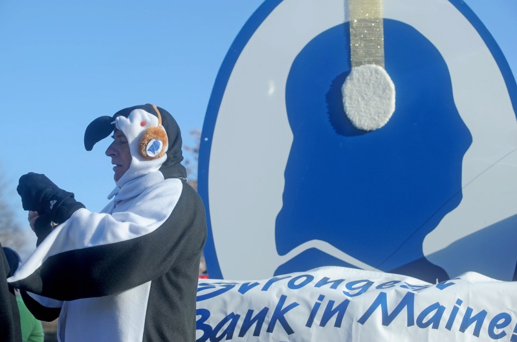 Peter Judkins, president of Franklin Savings Bank, takes a picture while dressed like a penguin at the annual Chester Greenwood Day parade in downtown Farmington on Saturday.